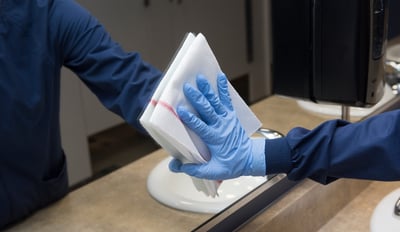 person cleaning bathroom window 