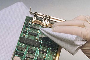 hand in glove wiping a microelectronic chip
