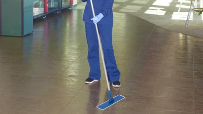 nurse in navy scrubs mopping the floor 