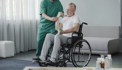 man in wheel chair doing therapy with nurse